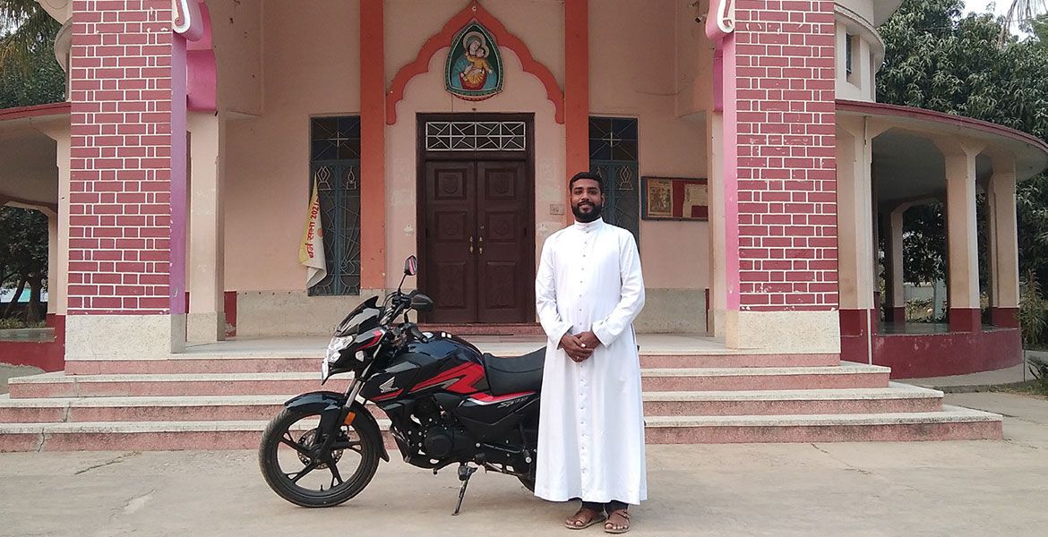 Priester mit Motorrad in Indien