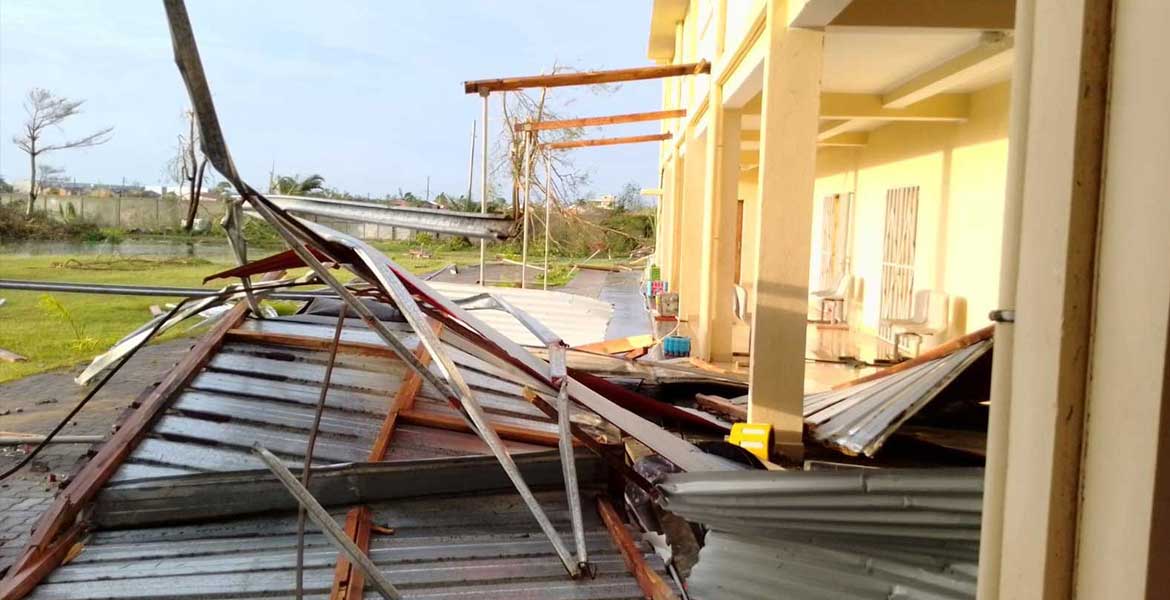 Das durch einen Zyklon zerstörte Frauenhaus von Don Bosco in Madagaskar: Das Dach aus Holz und Wellblech liegt zerdrückt und verbogen auf dem Boden neben dem Gebäude.