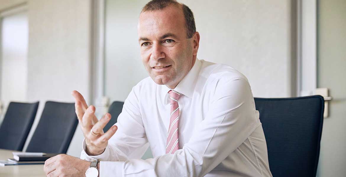 Der CSU-Politiker Manfred Weber sitzt an einem Konferenztisch.