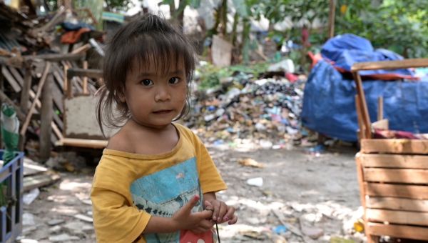 Ein kleines Kind, das auf der Straße lebt im Großraum Manila, blickt in die Kamera