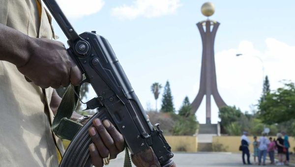 Im Vordergrund links im Bild sind die Hände eines Soldaten zu sehen, der ein Maschinengewehr hält. Im Hintergrund das Wahrzeichen der Stadt Mekele in Tigray/Äthiopien: Das Denkmal der Märtyrer.