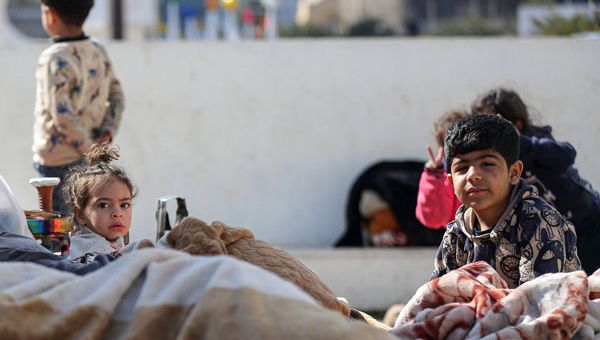 Kinder sitzen in Decken gehüllt auf der Straße. Sie sind mit ihrer Familie vor Bomben aus einem Vorort im Süden Beiruts geflohen