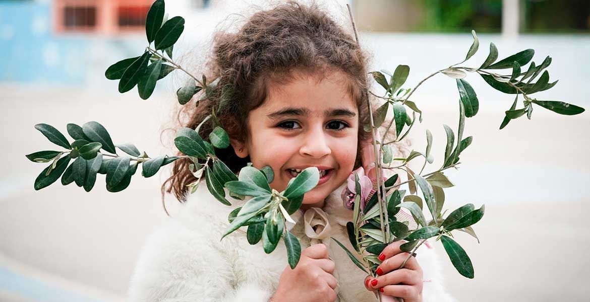 Syrisches Mädchen mit Olivenzweigen während einer Palmsonntagsprozession des Don-Bosco-Zentrums in Damaskus, Syrien.