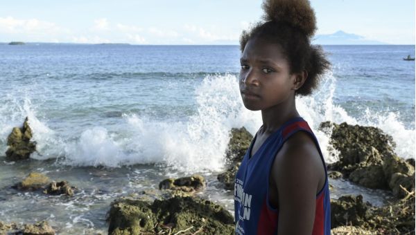  Joey Saileu, ein Mädchen, dessen Lebensraum durch Klimawandel bedroht ist, blickt in die Kamera