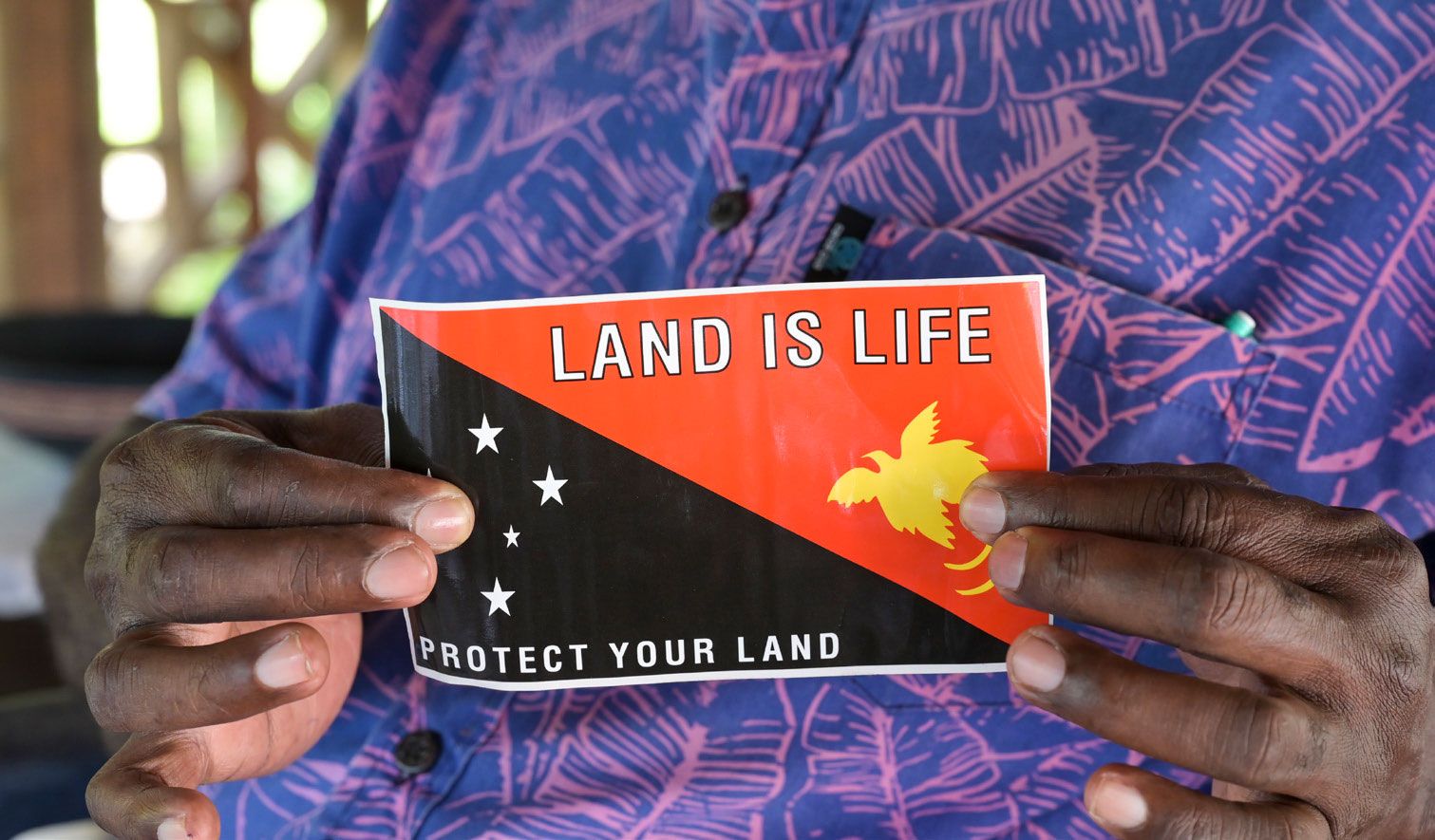 Eine indigene Frau hält die Flagge von Papua-Neuguinea hoch