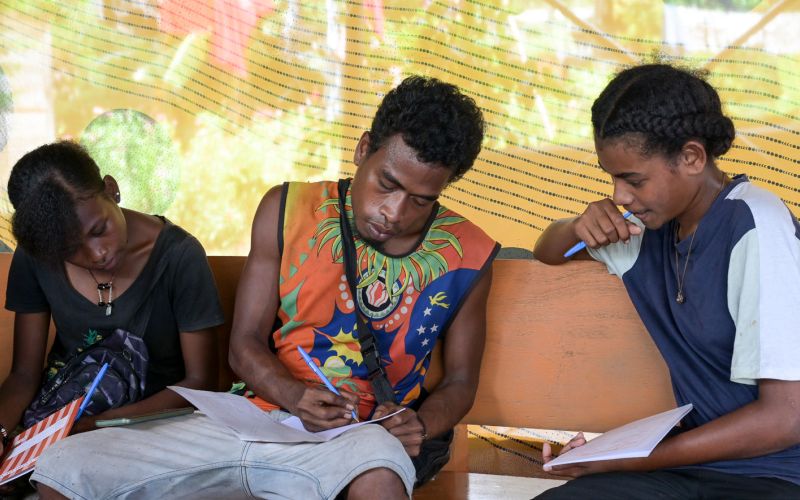 Junge Männer sitzen in einem Workshop zur Umweltbildung auf Papua-Neuguinea