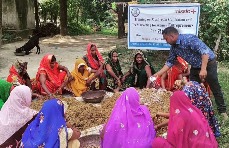 Frauen sitzen in Indien in einem Kreis auf dem Boden.