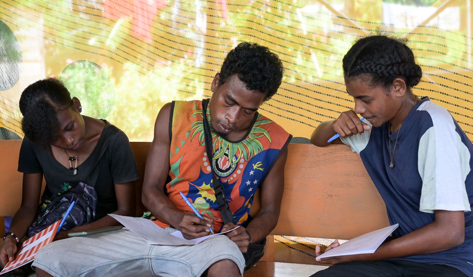 Junge Männer sitzen in einem Workshop zur Umweltbildung auf Papua-Neuguinea