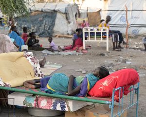 Ein geflüchtetes Kind aus dem Sudan liegt auf einem Bettgestell im Flüchtlingszentrum in Renk