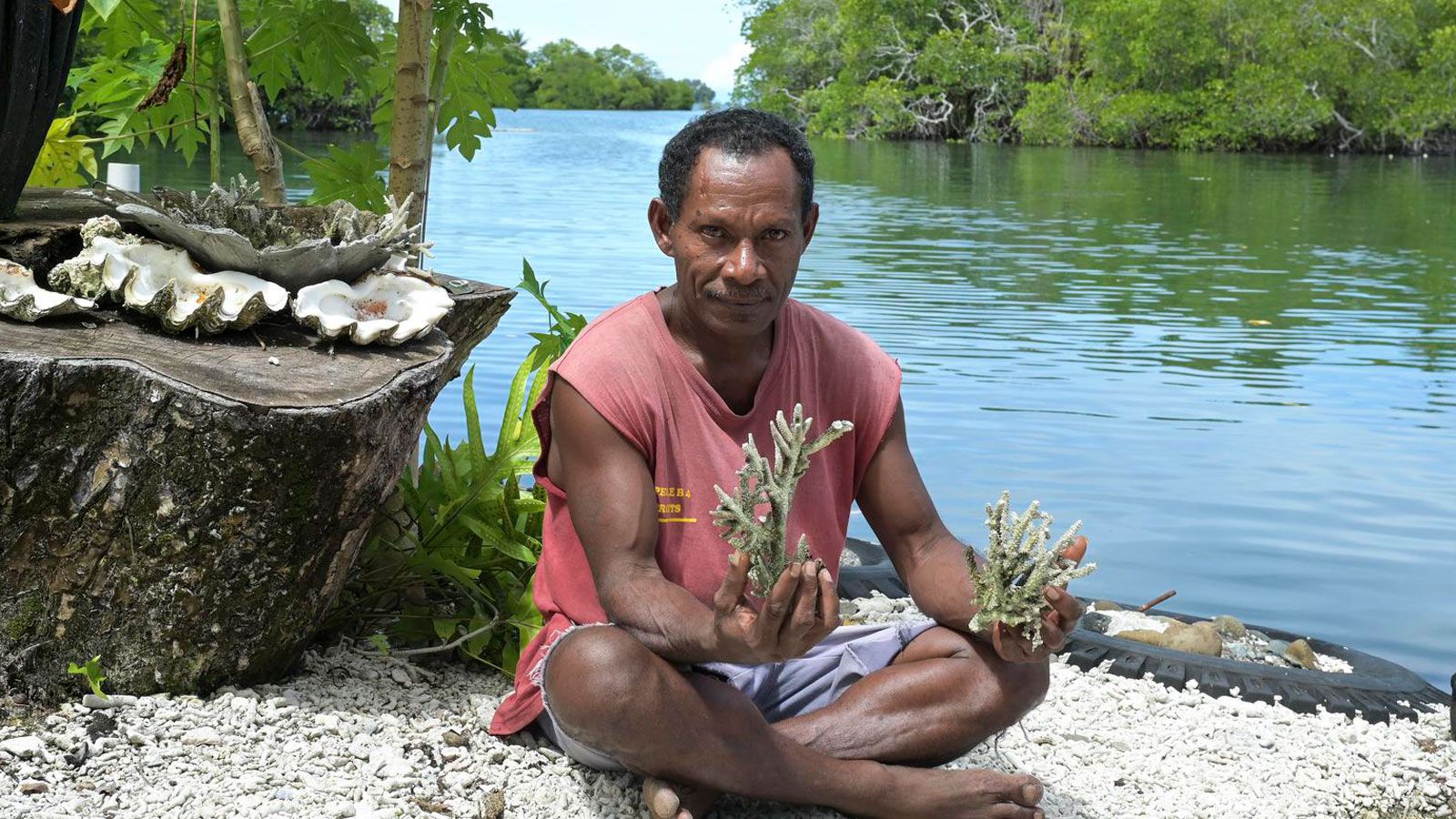 Ein Umweltaktivist aus Papua-Neuguinea hält Korallen zur Renaturierung in die Kamera