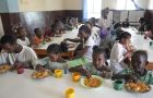 Kinder sitzen im Speisesaal des Waisenhauses St. Clare und essen