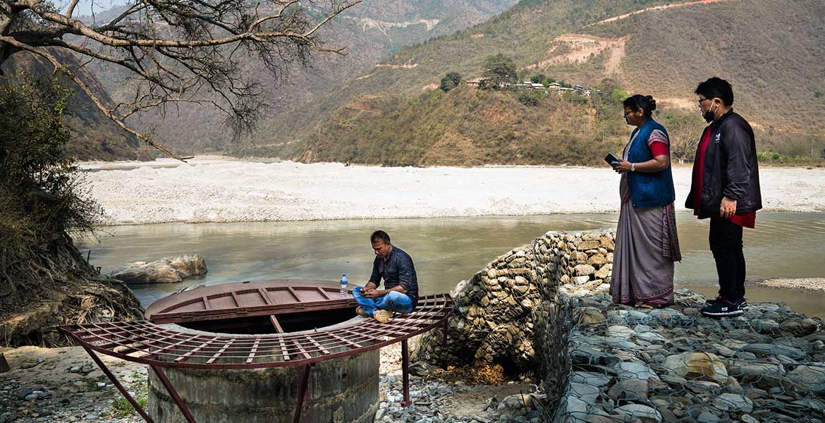 Menschen aus dem Dorf Koshidekha in Nepal stehen unten am Fluss. Ihr Wasserproblem ist gelöst.