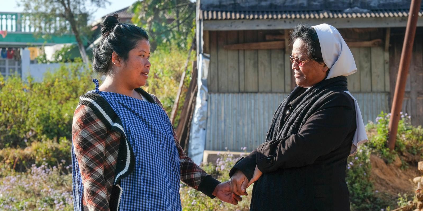 Sr. Martina hält die Hand einer Frau in einem Dorf im Bundesstaat Meghalaya, Nordostindien 