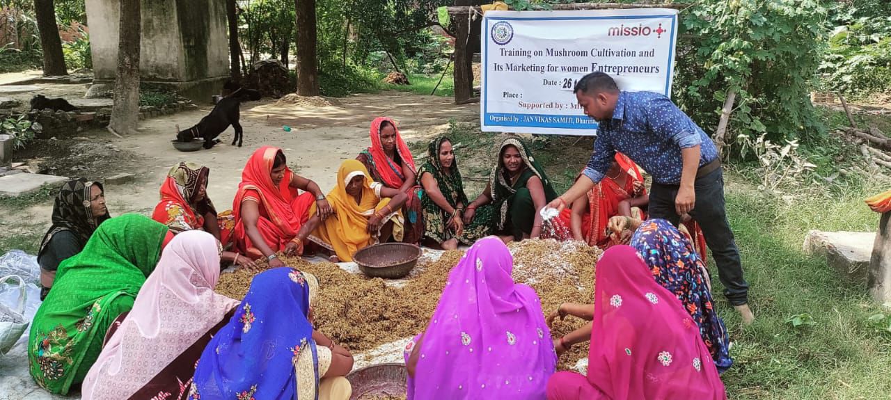 Frauen sitzen in Indien in einem Kreis auf dem Boden. 