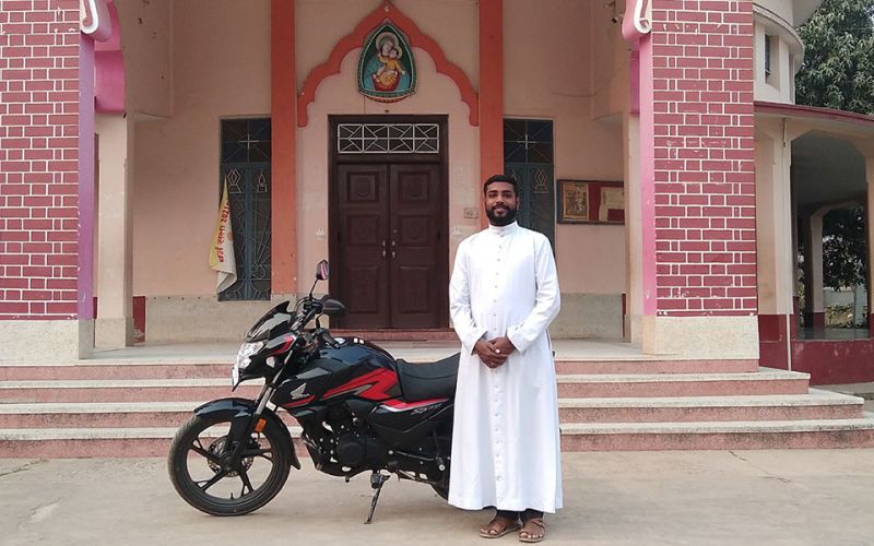 Priester mit Motorrad in Indien