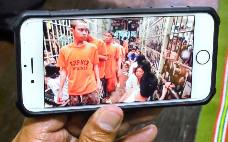 Der Generalsekretär der bischöflichen Kommission für Gefängnisseelsorge in Manila zeigt Fotos von überbelegten Gefängniszellen auf seinem Smartphone